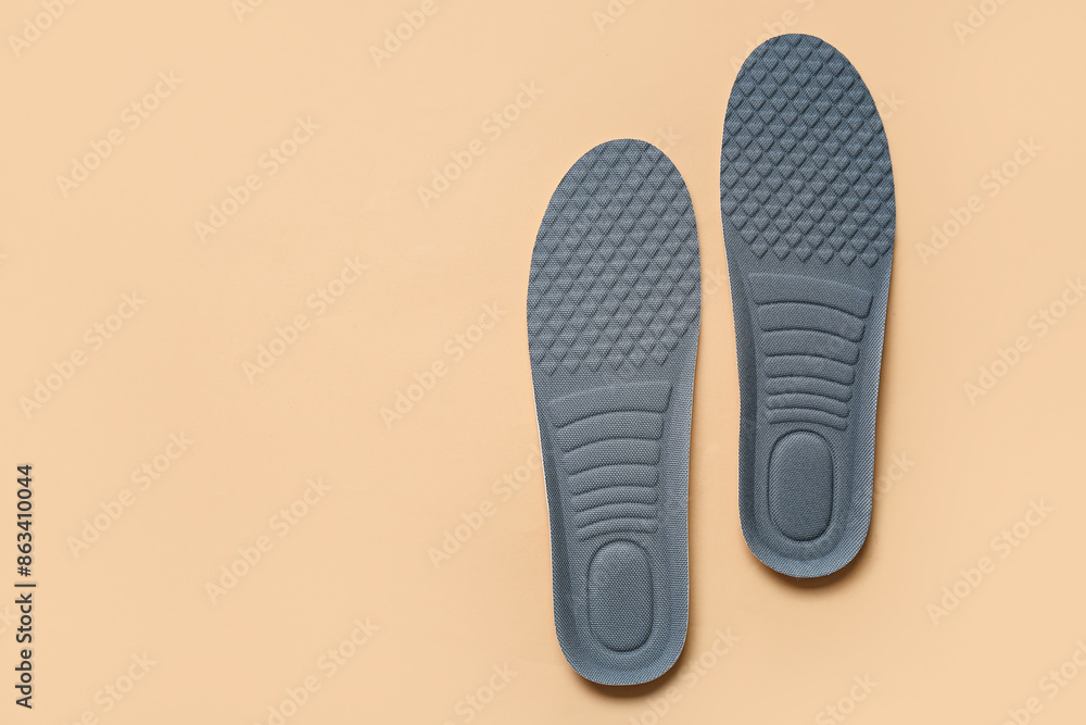 Grey orthopedic insoles on beige background