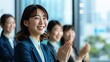 © Alice a. - A group of women in business attire are smiling and clapping. Scene is positive and celebratory