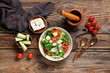 © Pixel-Shot - Bowl of fresh vegetable salad with cucumber and feta cheese on wooden background