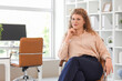 © Pixel-Shot - Young businesswoman sitting on armchair in office