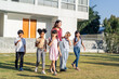 © Kawee - Group of children eating an ice cream with teacher together in garden.
