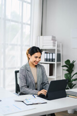 Wall Mural - Confident Asian Business Woman Working on Laptop in Modern Office Environment