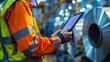 © suphamit - Factory scene with aluminum sheet metal rolls, worker in protective clothing, inspecting quality with a digital tablet