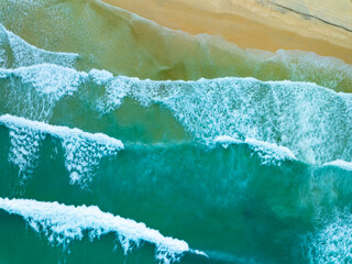 Poster - Aerial view sandy beach and waves crashing on sandy shore, Beautiful tropical sea surface background