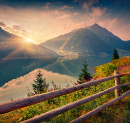 Wall Mural - Dramatic summer sunrise on Resia (Reschensee) lake. Resia village in the morning mist,  Province of Bolzano - South Tyro, Italy, Europe. Beauty of countryside concept background..