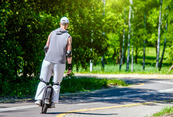 Wall Mural - guy on a monowheel ride through the city Park
