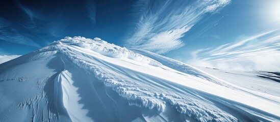 Wall Mural - Winter Wonderland: Snow-Covered Mountain Peak Under a Blue Sky