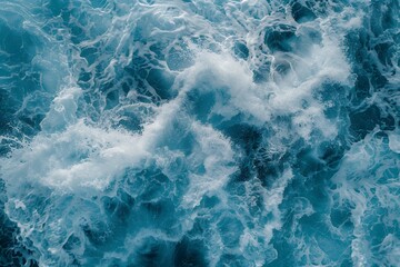 Aerial view of large waves in the ocean, texture of sea foam from a drone's perspective. Blue background with white water splashes and spray. Top down view of a natural landscape. Wild natural scene. 