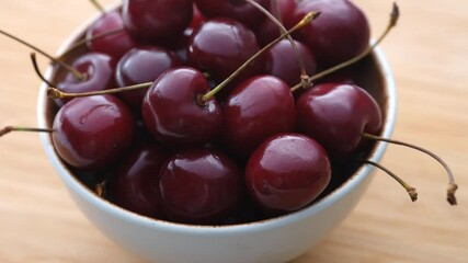 Wall Mural - Fresh organic sweet cherries in a bowl on a wooden background. Rotating 360 Degrees Video