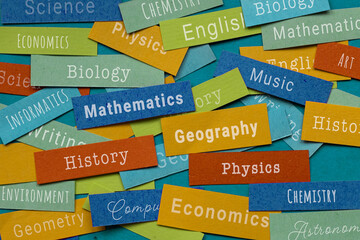 school education, many school subjects names written on colorful papers, learn mathematics history chemistry physics geography economics informatics