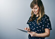 © peopleimages.com - Smile, typing and woman with tablet in studio for email, contact or text on internet connection. Scroll, mockup and girl on digital app for online chat, social media or web post on white background