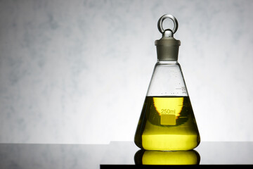 Sticker - Glass flask placed in a laboratory table with yellow liquid