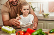 © Valerii Apetroaiei - Father and Daughter Cooking Together in the Kitchen and preparing a nutritious meal