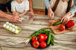 © Valerii Apetroaiei - Family enjoys cooking together in the kitchen with fresh vegetables and ingredients