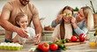 © Valerii Apetroaiei - The family is joyfully cooking together in a welllit kitchen using fresh ingredients