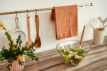 Create a welcoming atmosphere in your kitchen with salad and wooden utensils for a modern look