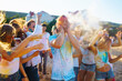 © maxbelchenko - Holi festival. Young people with colorful paint on clothes and bodies have fun together. Beach party. Friendship, rest, holidays.