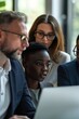© Alexander Chaykin - Group of people sitting together looking at laptop screen, possibly discussing or working on project