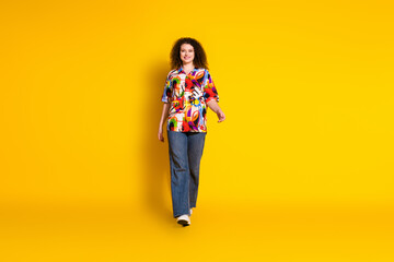 Wall Mural - Full size photo of attractive young woman walking shopping dressed stylish colorful print clothes isolated on yellow color background