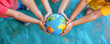 © LeManna - Children standing holding hands around earth globe. Global eco protection concept.