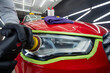 © Mia - Professional worker with orbital polisher in auto repair shop, polishing car headlight. Close-up.