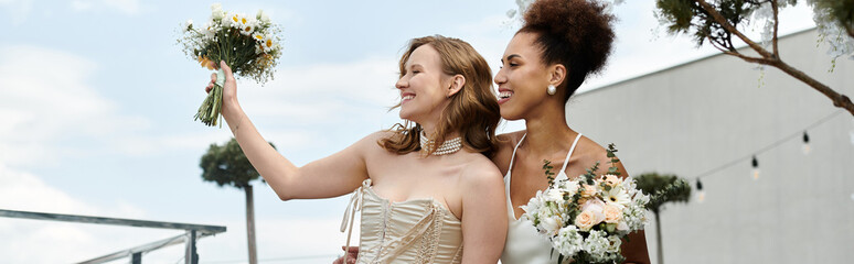 Wall Mural - Two brides, smiling and holding bouquets, on their wedding day.