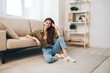 © SHOTPRIME STUDIO - Relaxing in a Cosy Apartment: A Happy Woman on a Modern Sofa, Enjoying the Comfort and Peaceful Atmosphere