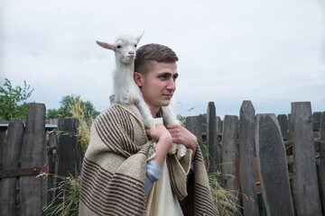 Wall Mural - Shepherd with a sheep in his arms