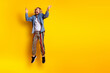 © deagreez - Full size photo of pretty young guy jumping excited wear trendy jeans outfit isolated on yellow color background