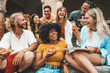 © Davide Angelini - Multicultural smiling friends eating pizza sitting outside - Cheerful young people enjoying summer vacation together - Happy life style concept with guys and girls hanging out on a sunny day