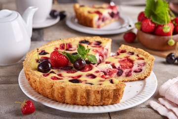 Canvas Print - Tart with cherries strawberries and custard milk cream filling. Open cheesecake pie. Delicious homemade summer dessert with berries. 