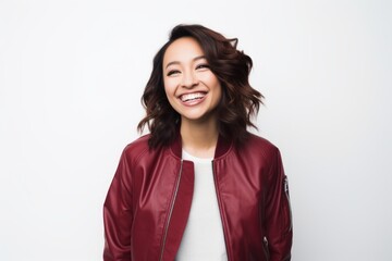 Wall Mural - Portrait of a blissful woman in her 30s wearing a trendy bomber jacket while standing against white background