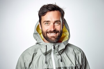Wall Mural - Portrait of a grinning man in his 30s wearing a lightweight packable anorak on white background
