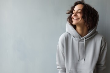 Wall Mural - Portrait of a joyful woman in her 50s sporting a comfortable hoodie isolated on modern minimalist interior