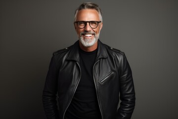 Wall Mural - Portrait of a happy man in his 50s sporting a classic leather jacket on modern minimalist interior