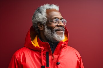 Wall Mural - Portrait of a blissful afro-american man in his 60s wearing a vibrant raincoat isolated in modern minimalist interior