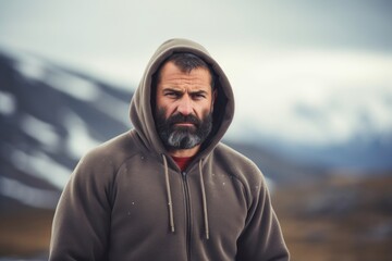 Wall Mural - Portrait of a merry man in his 40s sporting a comfortable hoodie isolated in snowy mountain range