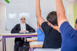 © Viga - Students raising their hands to answer the teacher question