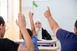 © Viga - Students raising their hands to answer the teacher question