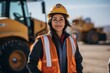 © Vorda Berge - Portrait of a female construction worker on site next to machinery