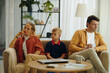 © DragonImages - Family sitting on sofa in the room with their little son and thinking about divorce