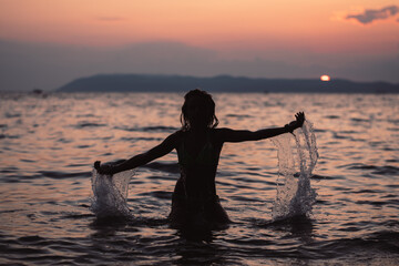 Wall Mural - girl splashing in the sea, summer vibes