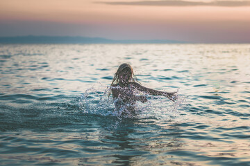 Wall Mural - girl splashing in the sea, summer vibes, happiness and joy