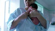 © Marco - Mother holding newborn baby close, wrapped in a striped hospital gown, highlighting the tender and protective bond, emphasizing early motherhood and the nurturing moments in a serene environment