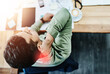 © SensSai/peopleimages.com - Neck pain, stress and businessman at desk in office with bad posture, burnout or body ache. Red glow, fatigue and male financial advisor with shoulder muscle sprain, injury or accident from above.