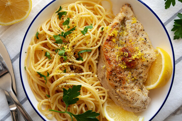 Wall Mural - Homemade Lemon Pepper Chicken with Spaghetti Pasta on a Plate, top view.