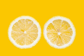 Wall Mural - Fresh lemon slices on yellow background.