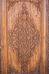 tajik kandakori patterns arabesque ornament on an ancient wooden carved door in Tajikistan close up