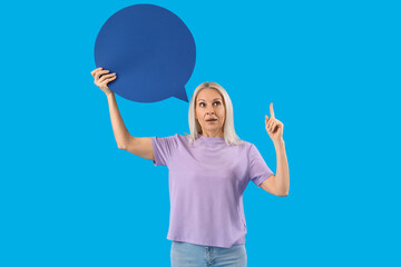 Poster - Mature woman with blank speech bubble pointing at something on blue background