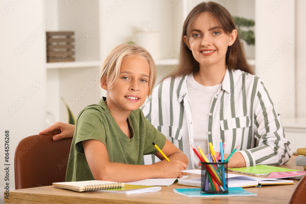 Little boy doing lessons with his mother at home